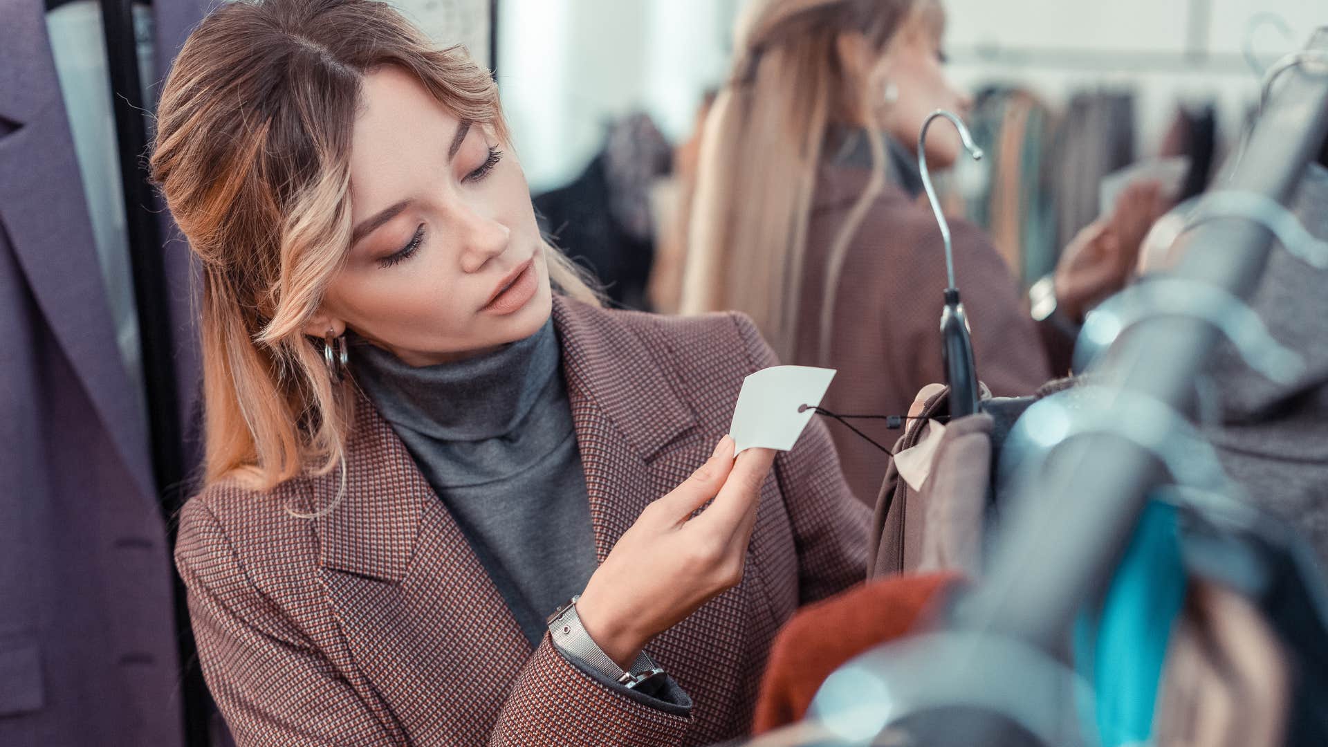 detail-oriented woman looking at clothing tags in a store