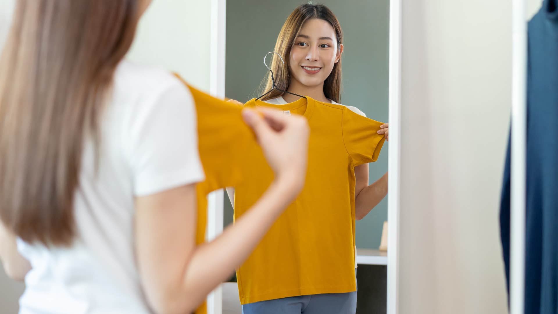 woman who enjoys solving problems looking in a mirror with a shirt