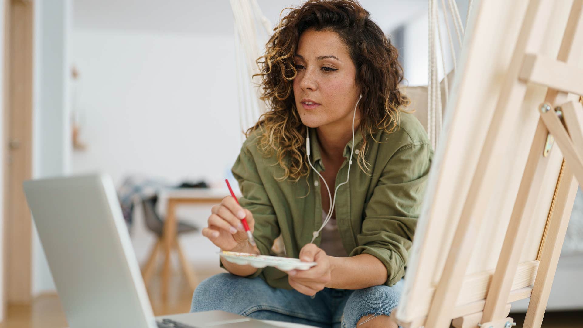 Incredibly creative woman painting at home.