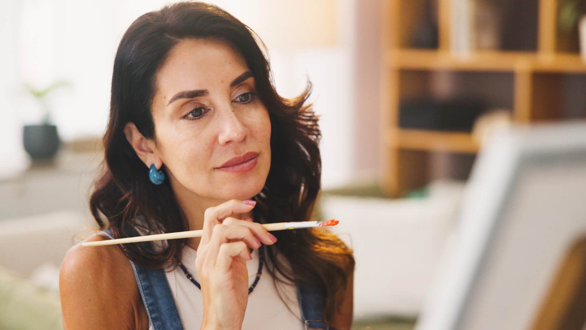 Woman with niche hobbies and interests painting at home.