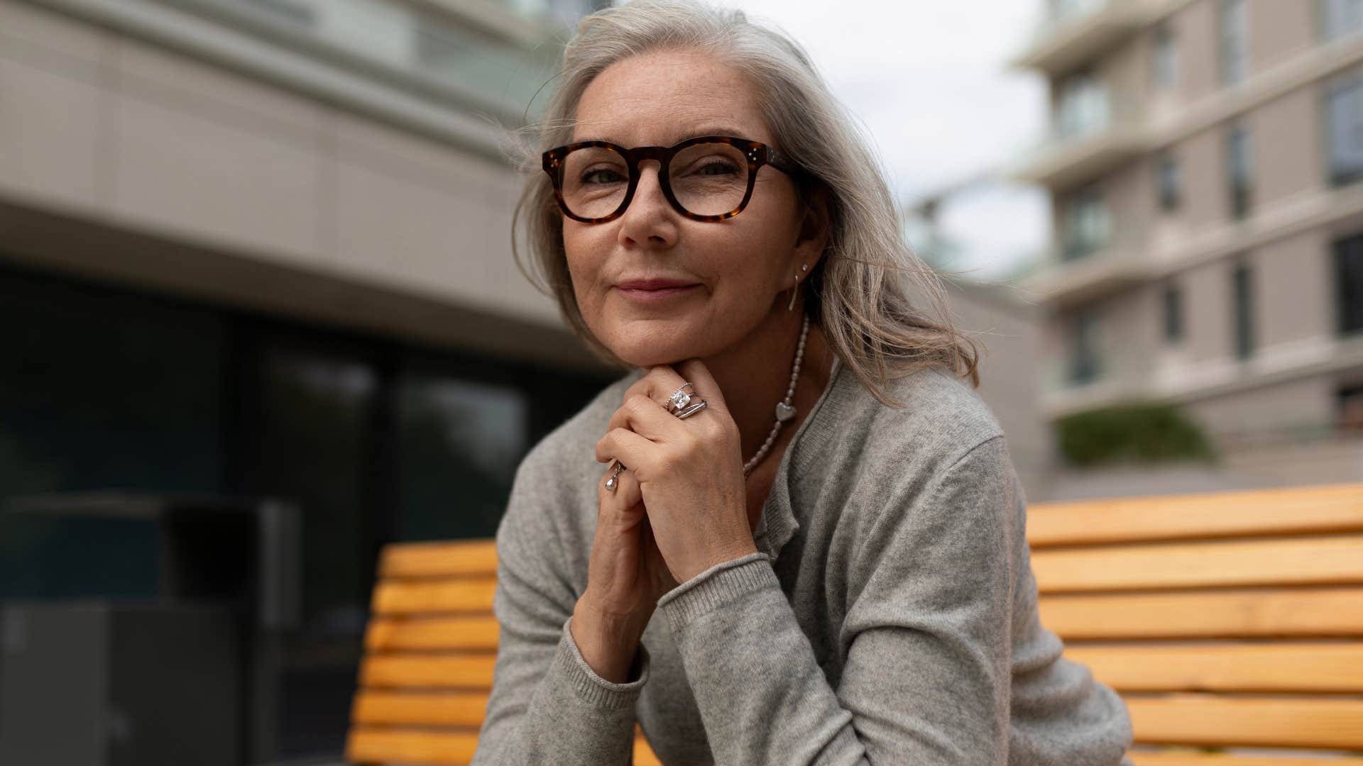 Quiet and intellectually humble woman sitting outside.