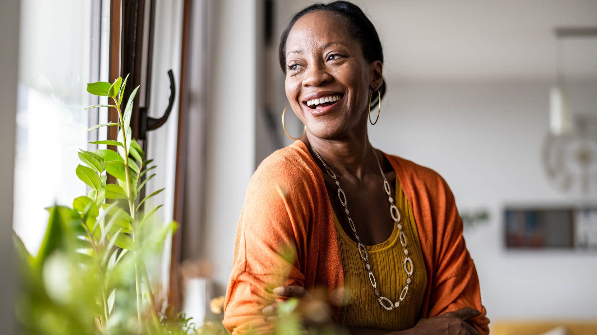 woman who is highly attuned to subtle beauty smiling with her plants