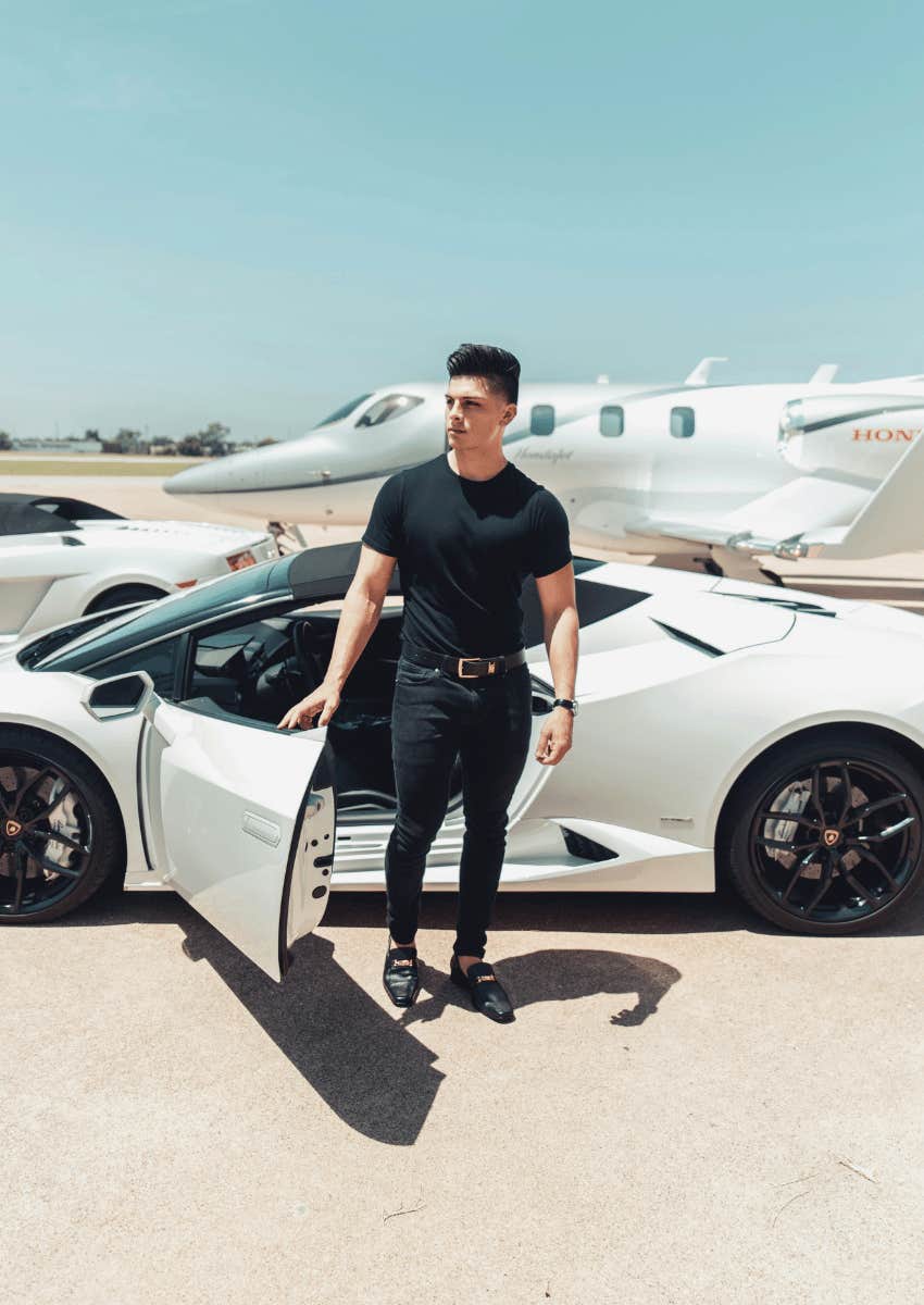 young man coming out of luxury car in front of jet on tarmac