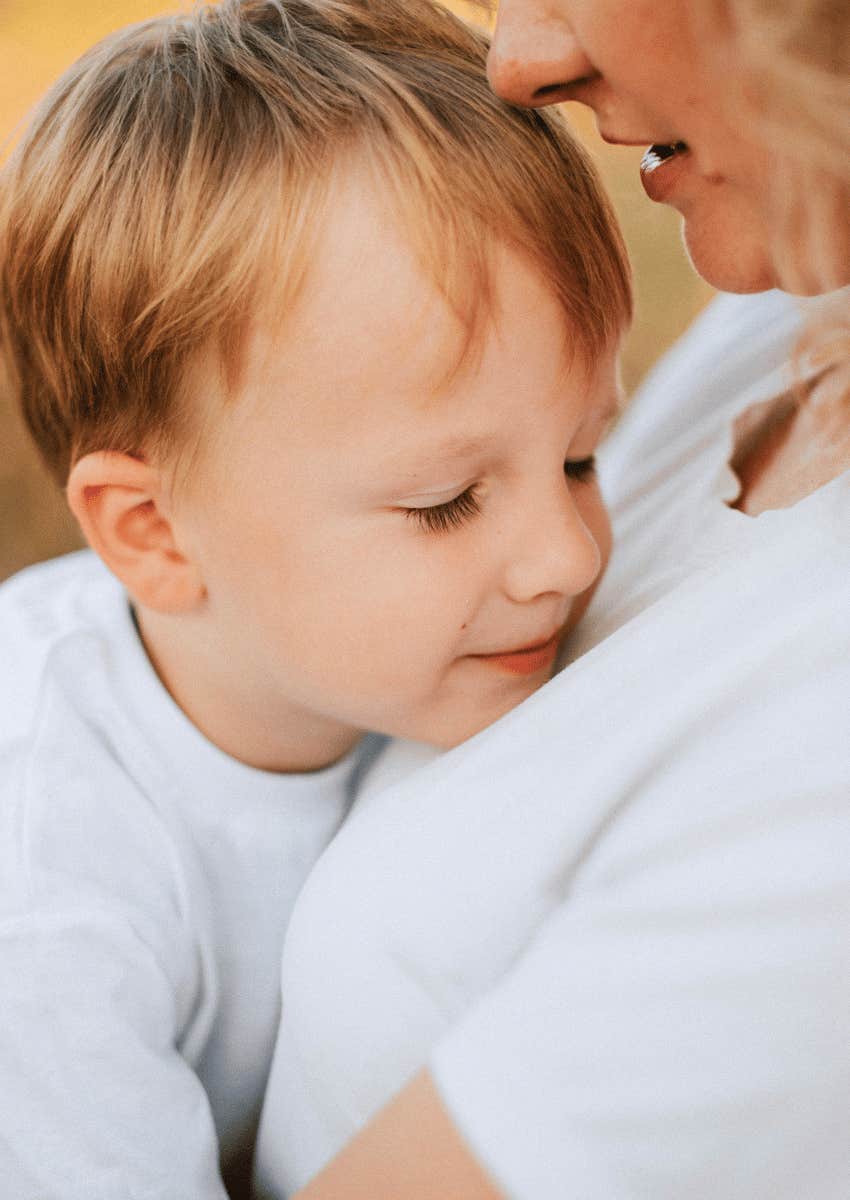 young son snuggled into his mom's arms