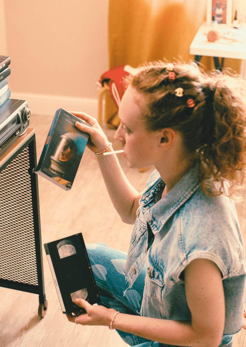 90s teen girl holding a VHS