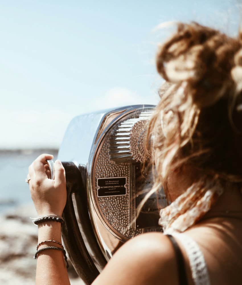 curious person uses binoculars showing emotional concept of zooming out