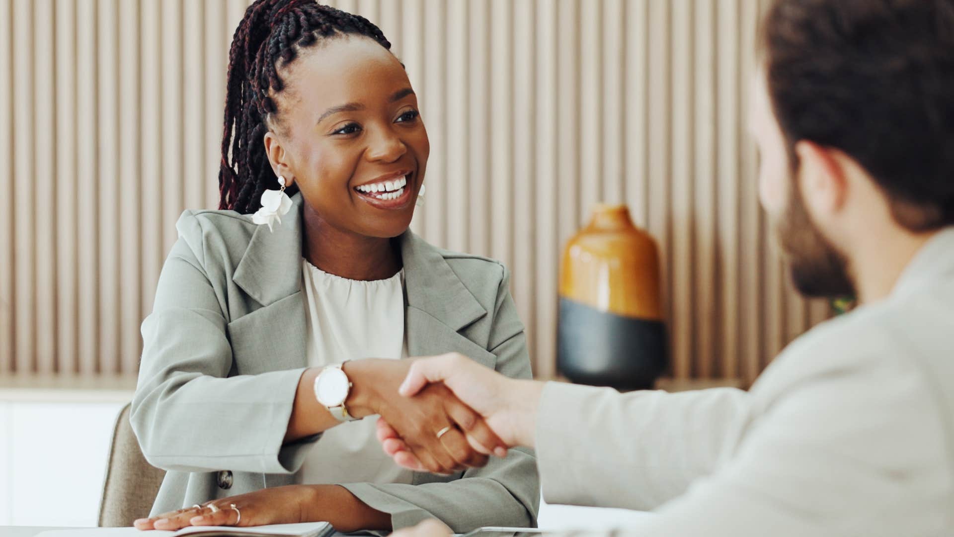 woman with good human manners greeting everyone in a room at work shaking hands