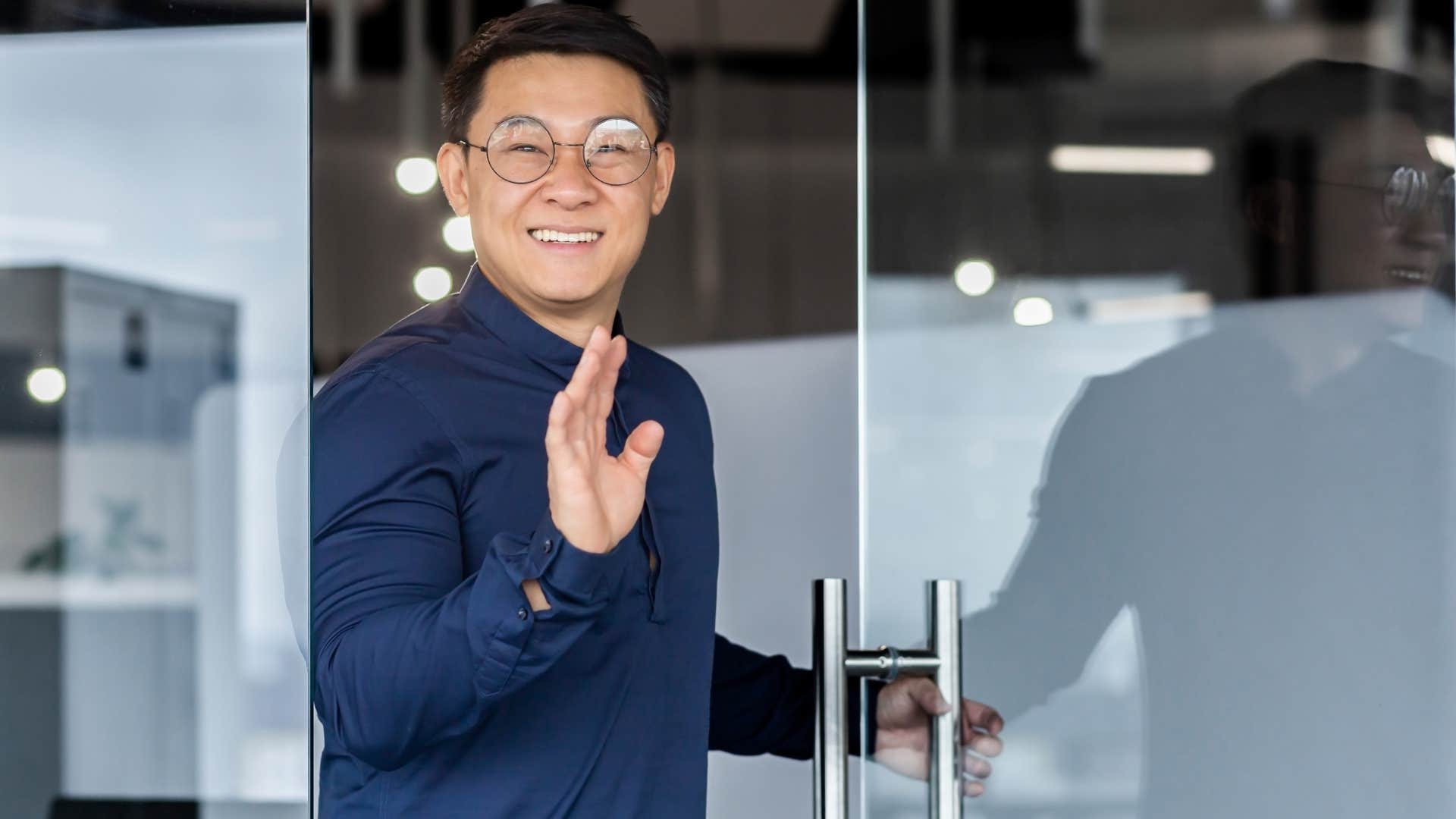 polite man holding a door open for a stranger at work