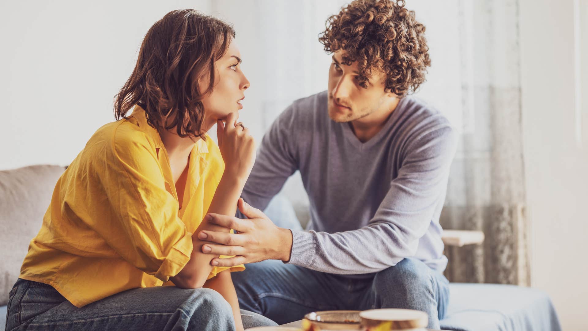 man saying sorry to his partner at home