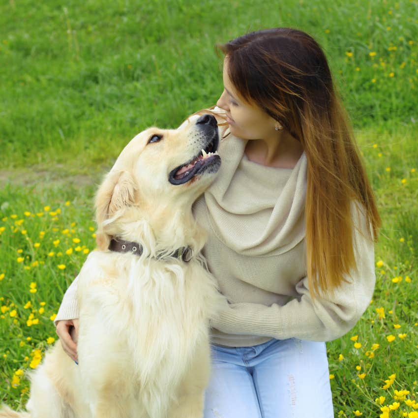 woman smiling at her dog let's him know she loves him