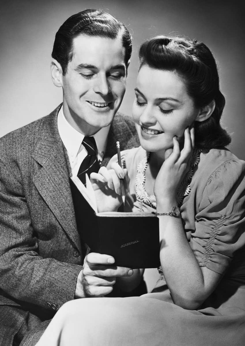 black and white couple writing in journal together