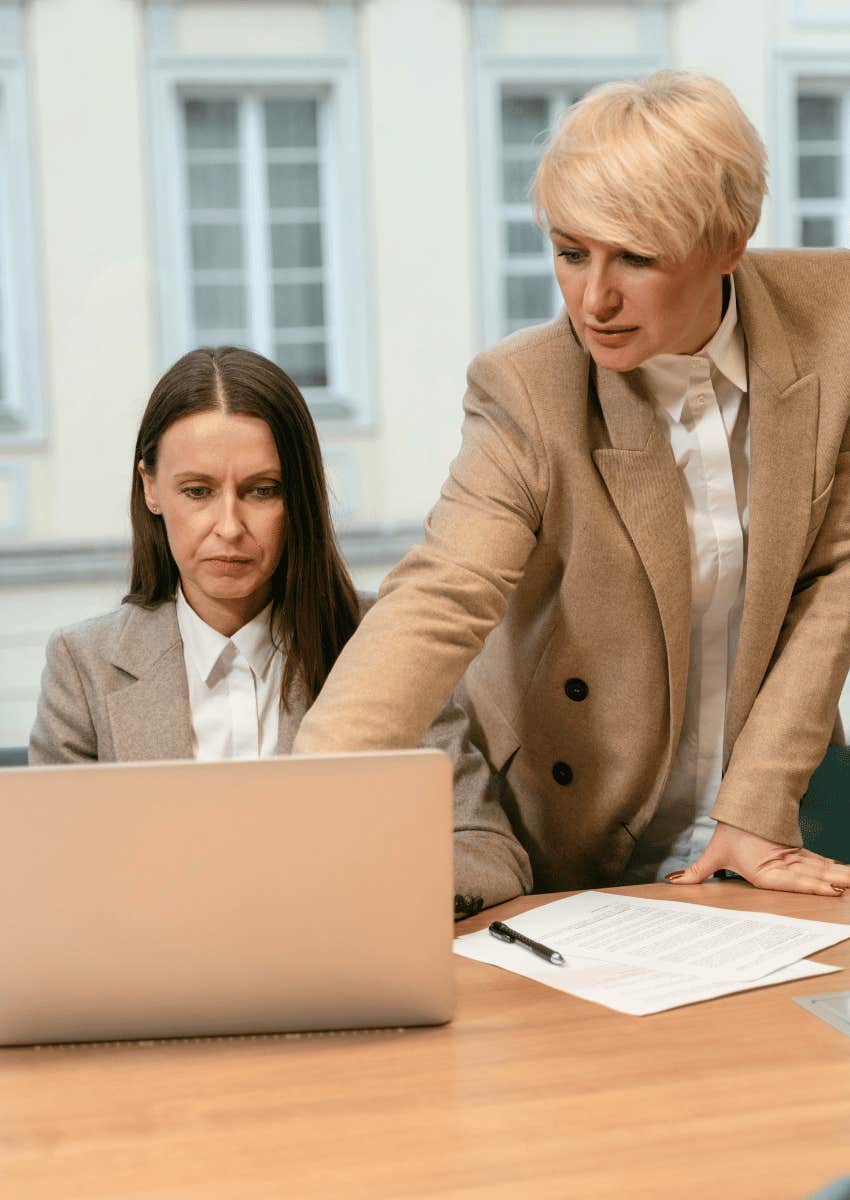 boss hovering over working employee