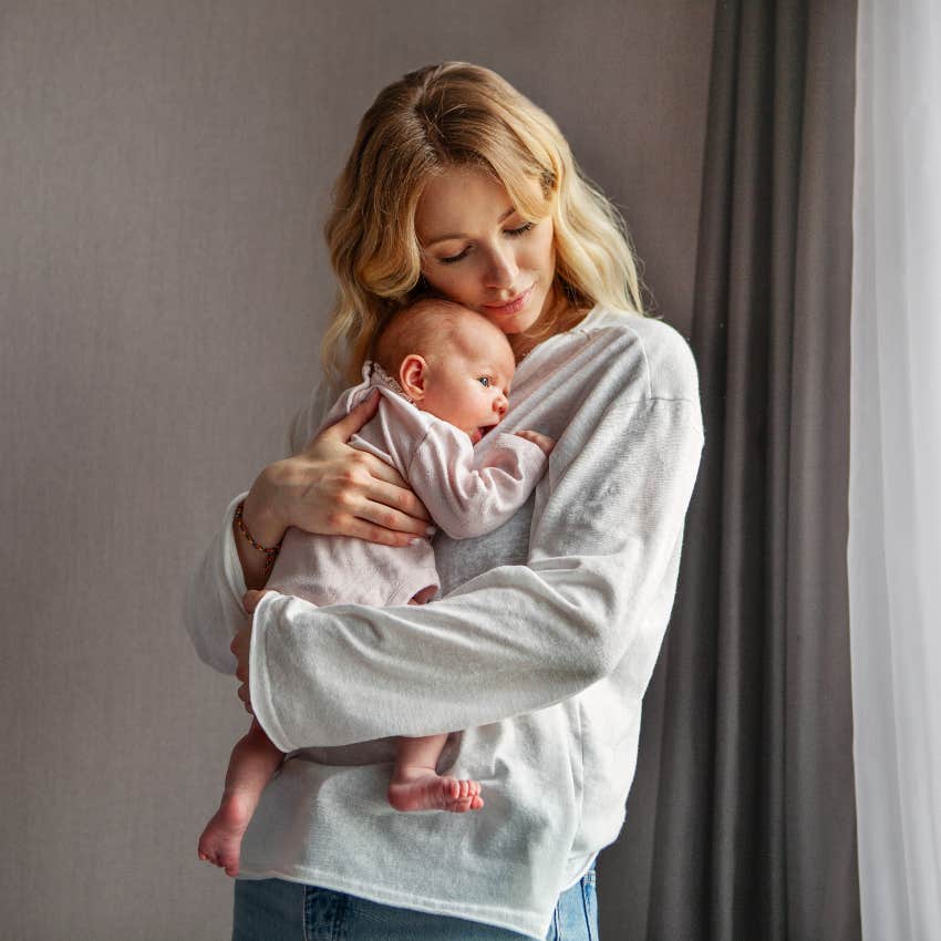 mom at home holding and taking care of newborn baby