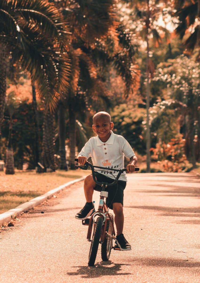 child riding bike smiling confidently