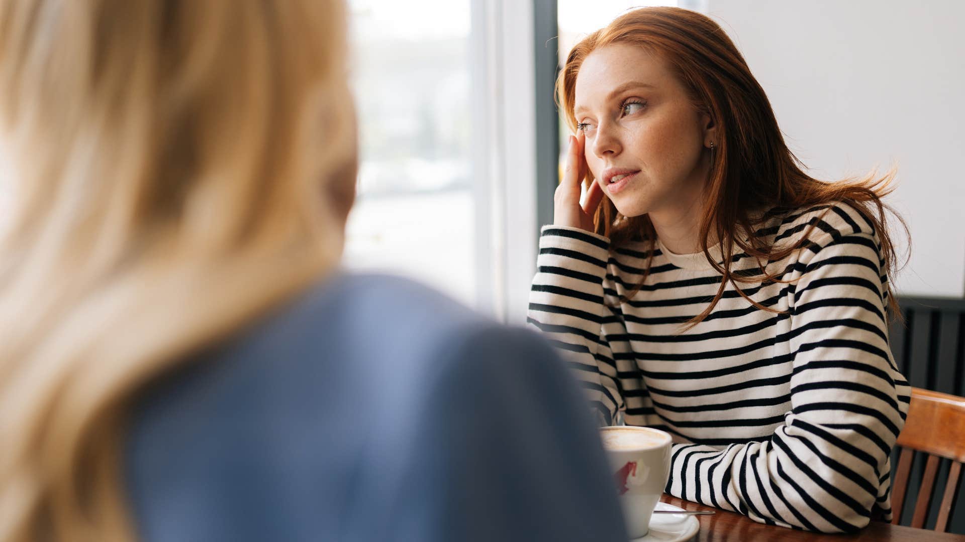 Woman saying "Why don't you talk to your family?" to an uncomfortable friend.