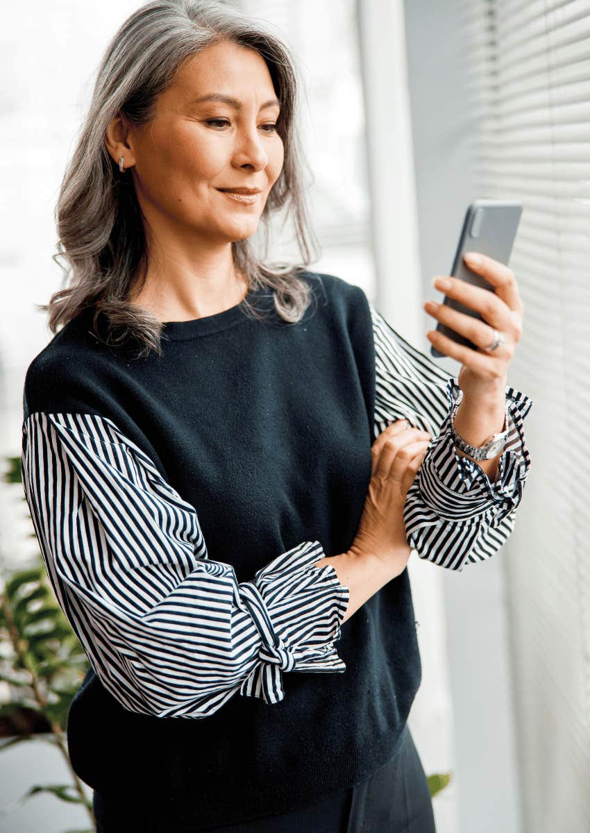 confident older woman looking at her phone