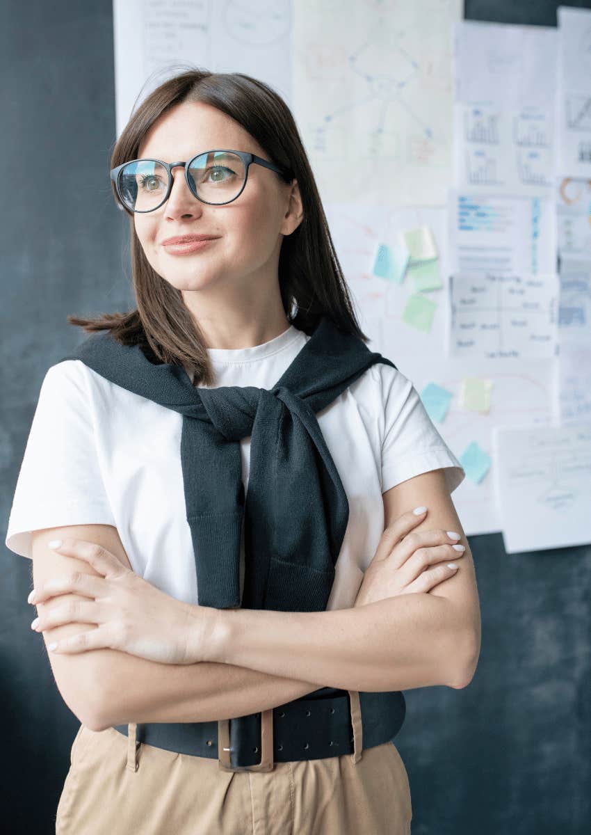 confident professional woman standing in front of board