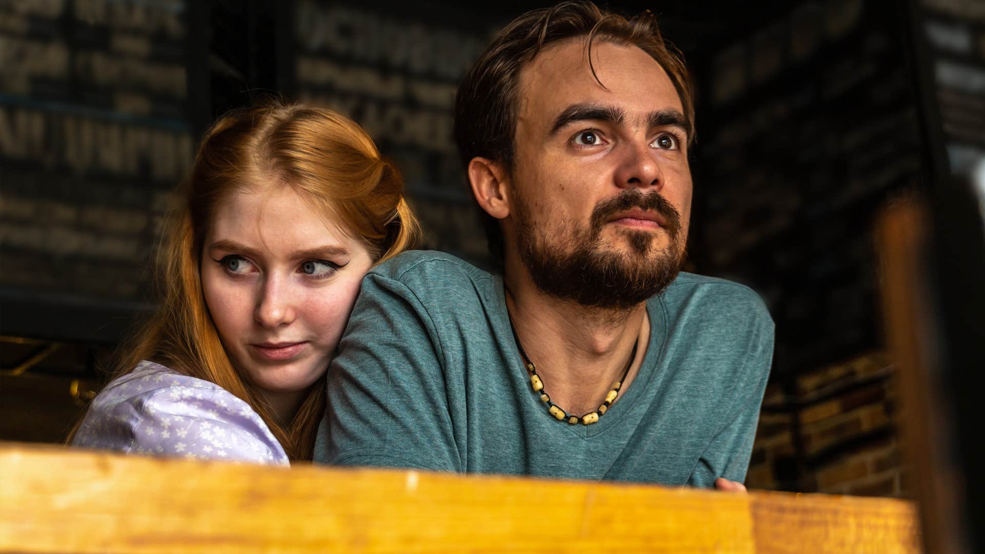 Controlling woman hugging a man but looking sneakily off to the side