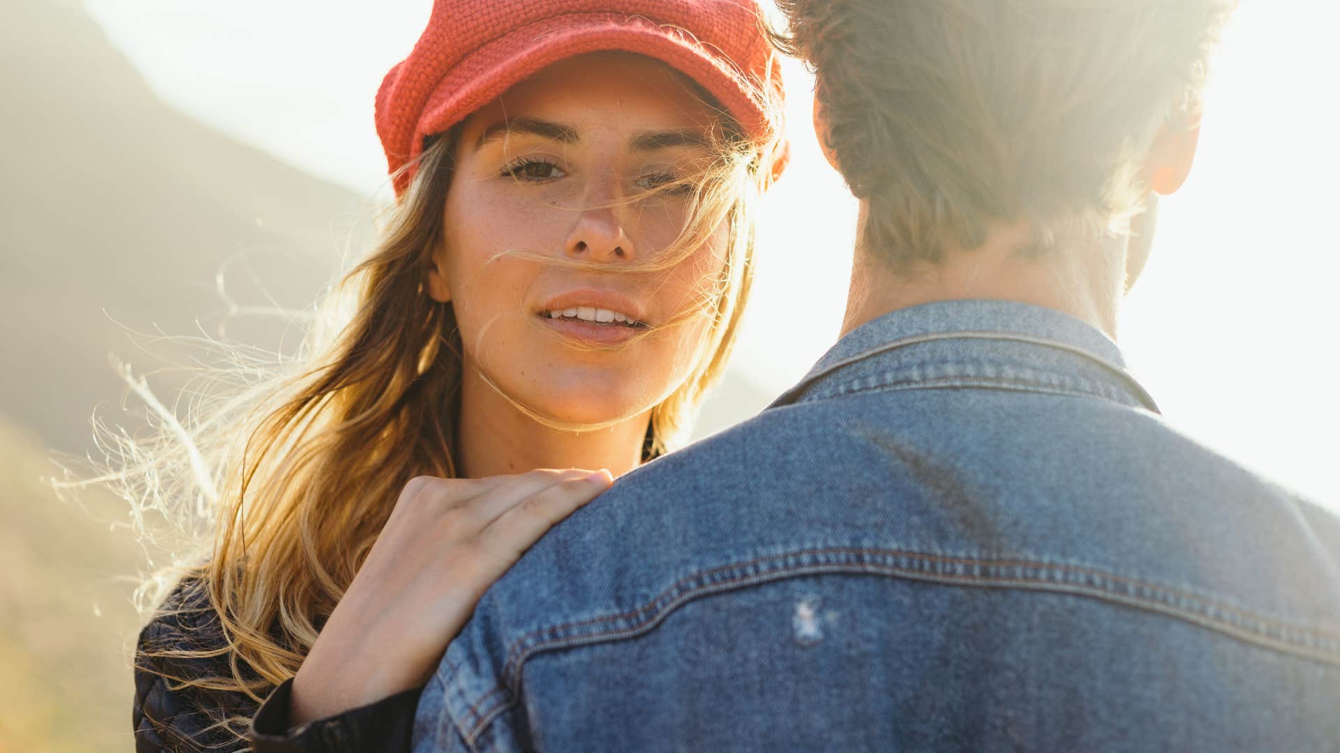 Controlling woman looking suspicious behind the back of a man who loves her