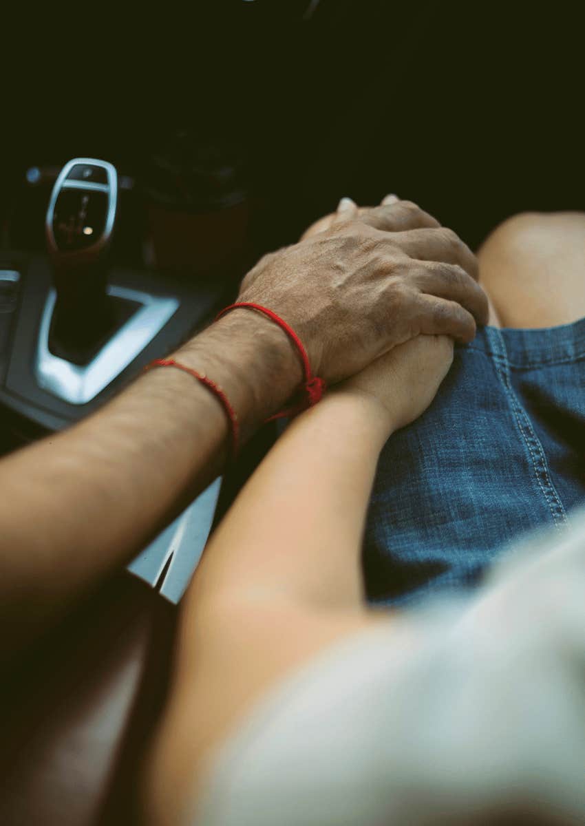 couple holding hands in car