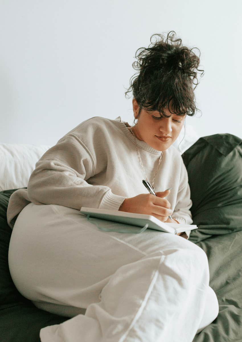 cozy young woman writing in her journal
