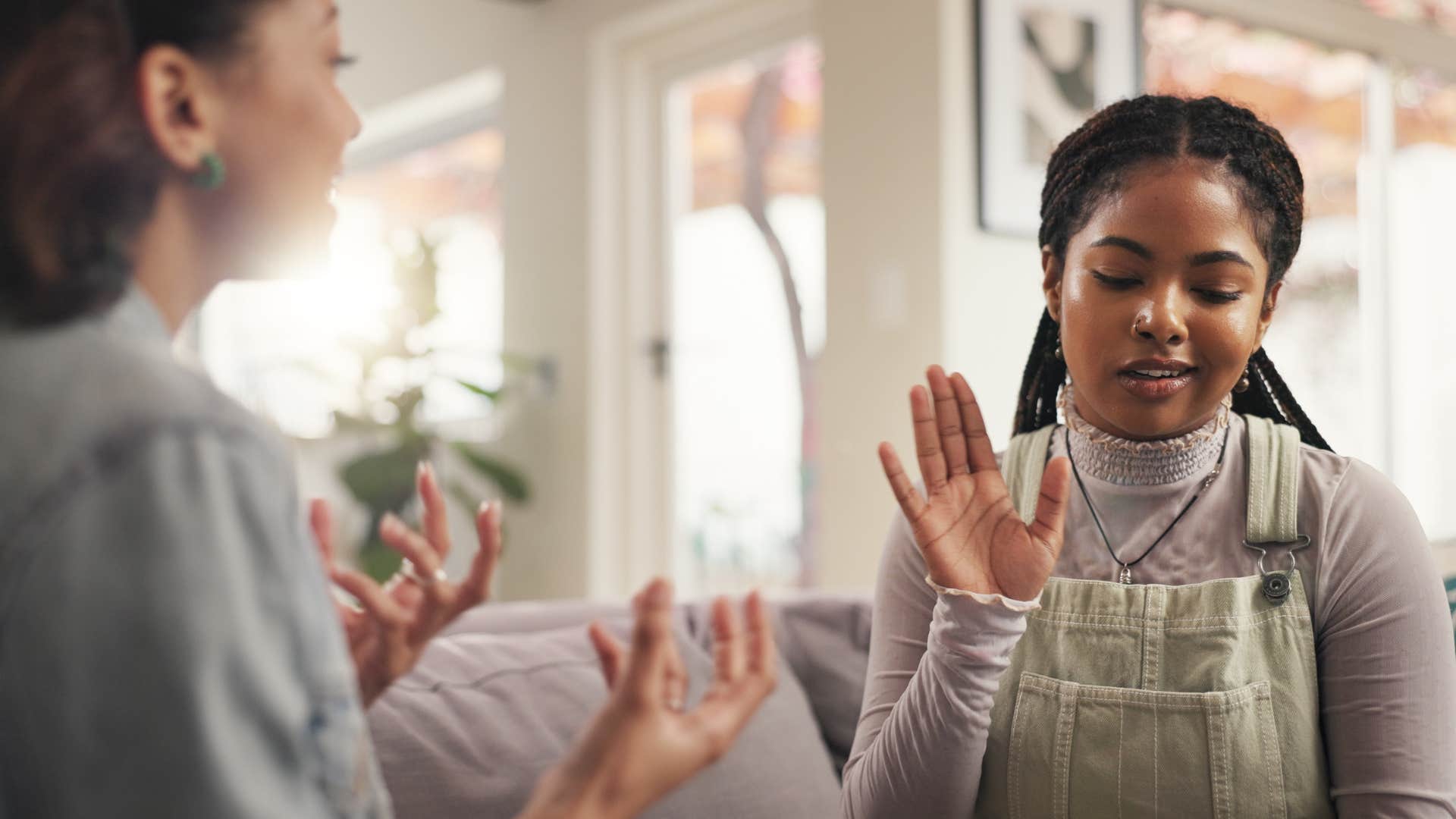 fake woman holding up her hand telling friend i never said that