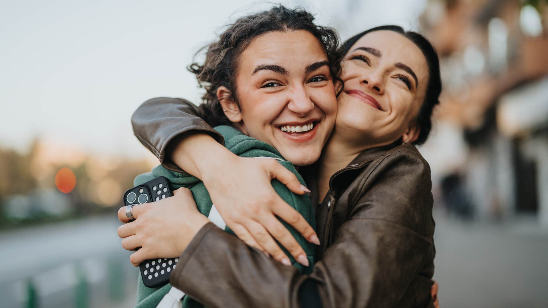 empathic woman hugging her best friend tightly smiling
