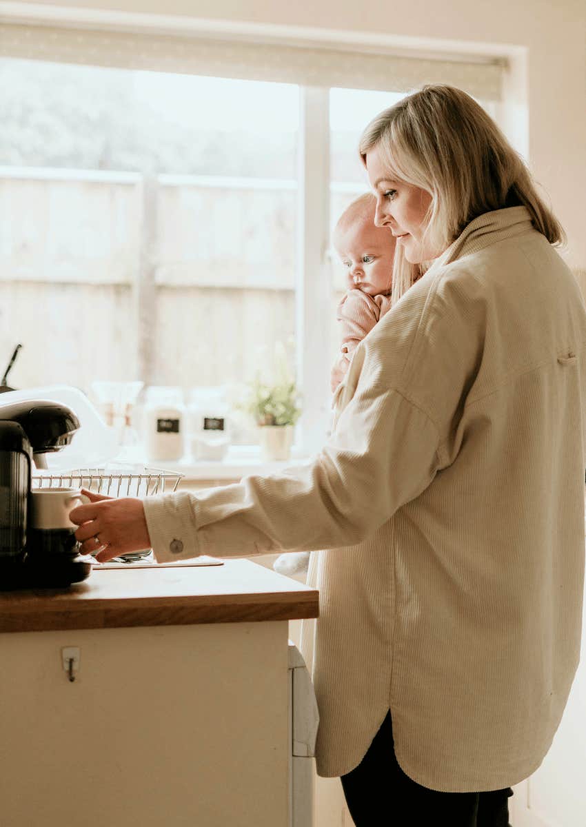 exhausted mom making coffee and holding baby