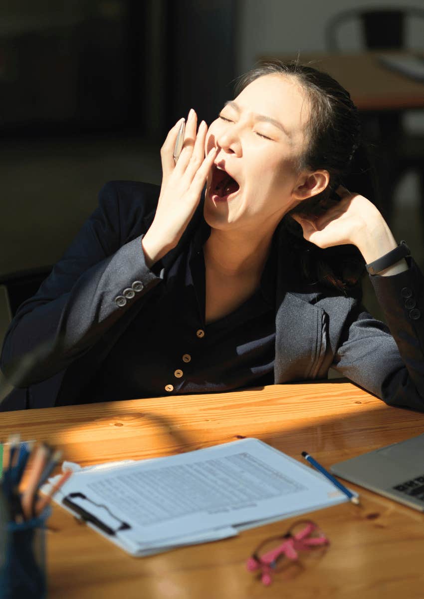 exhausted young adult woman yawning