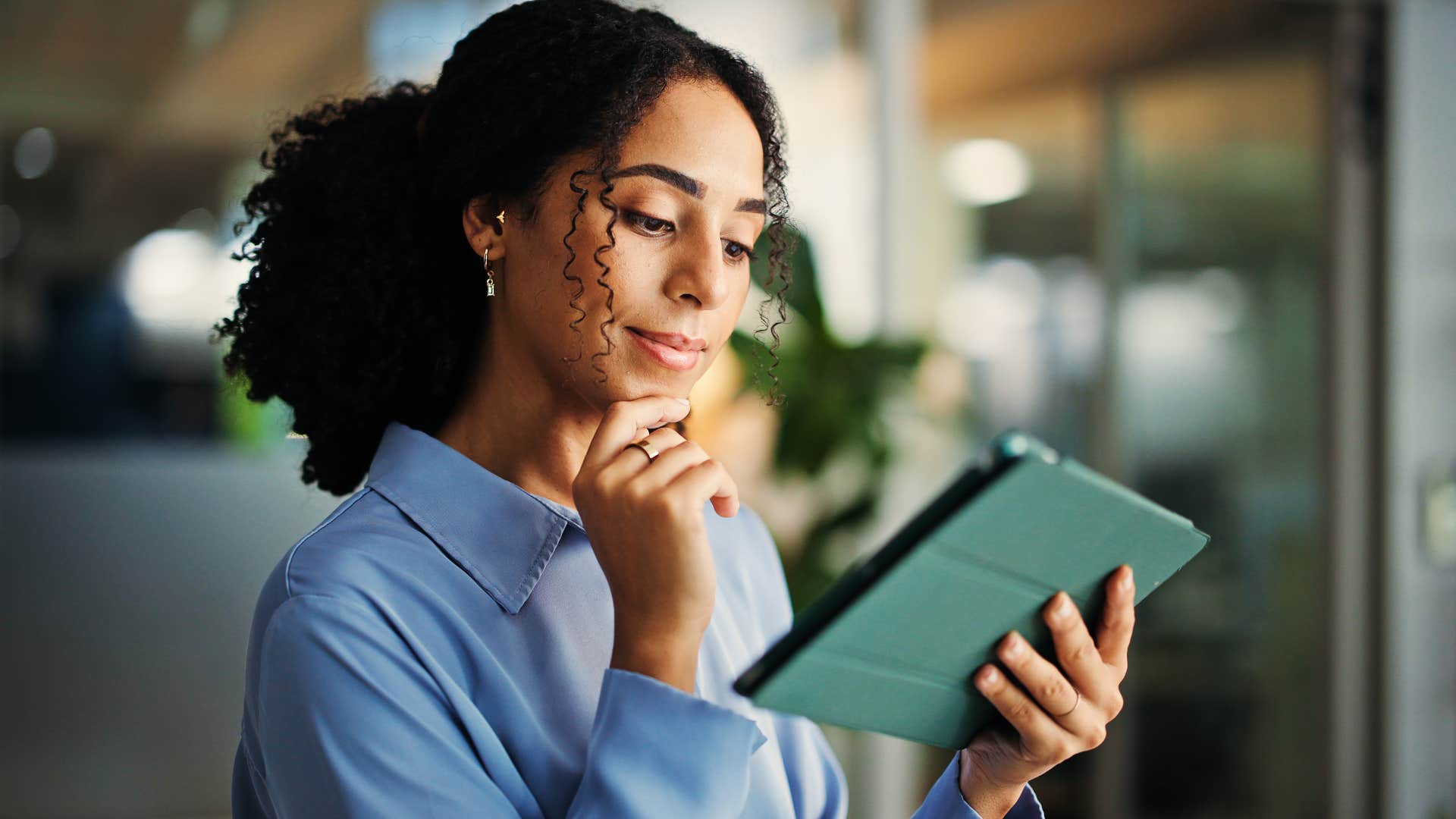 woman who's very intuitive smiling and thinking at work