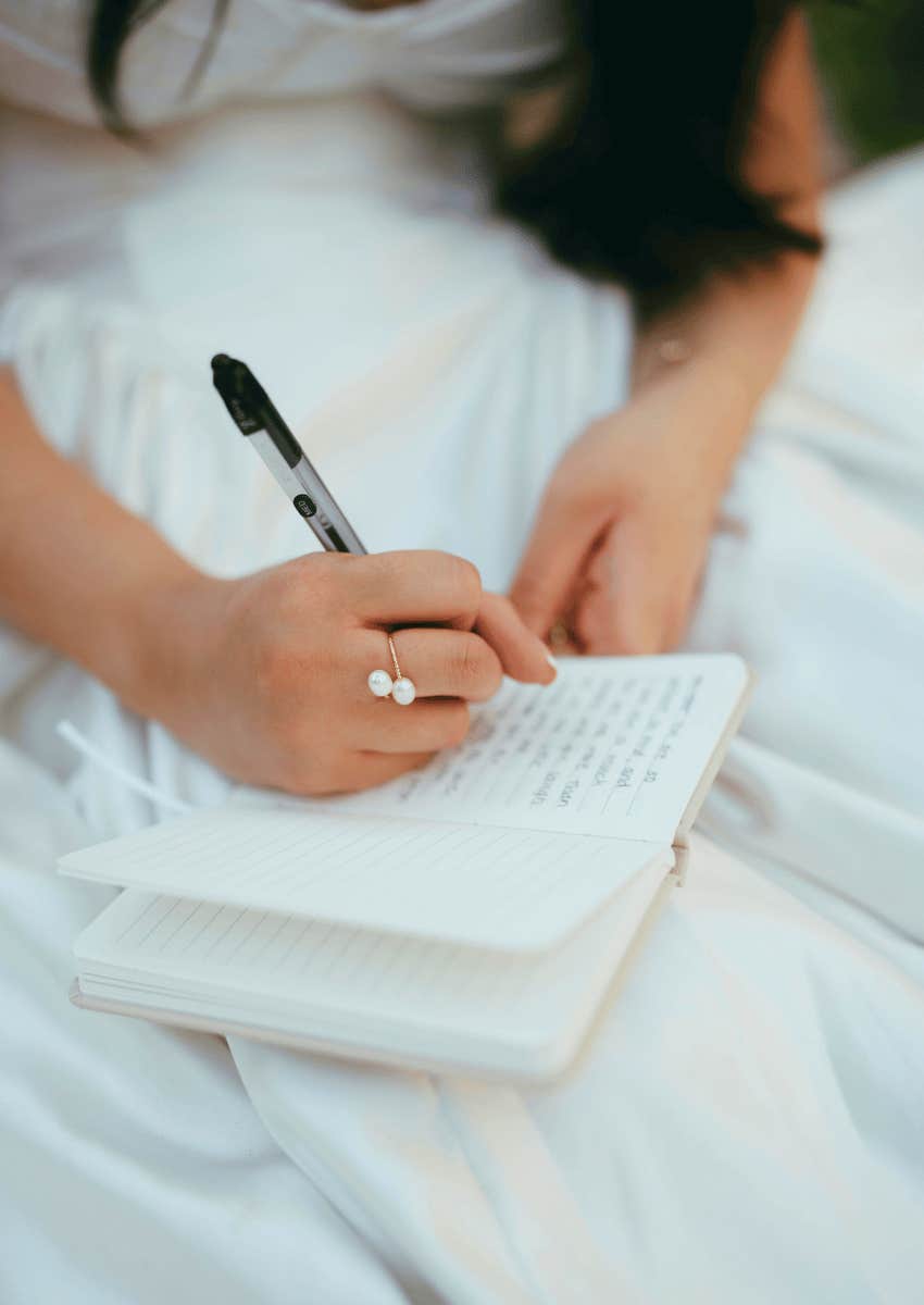 female hands writing inside of journal