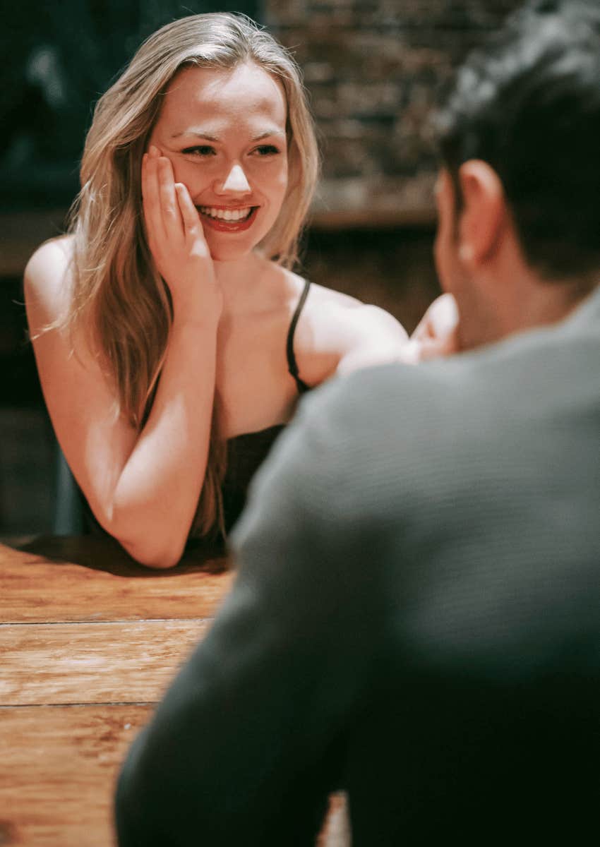 flustered woman smiling at man across of table
