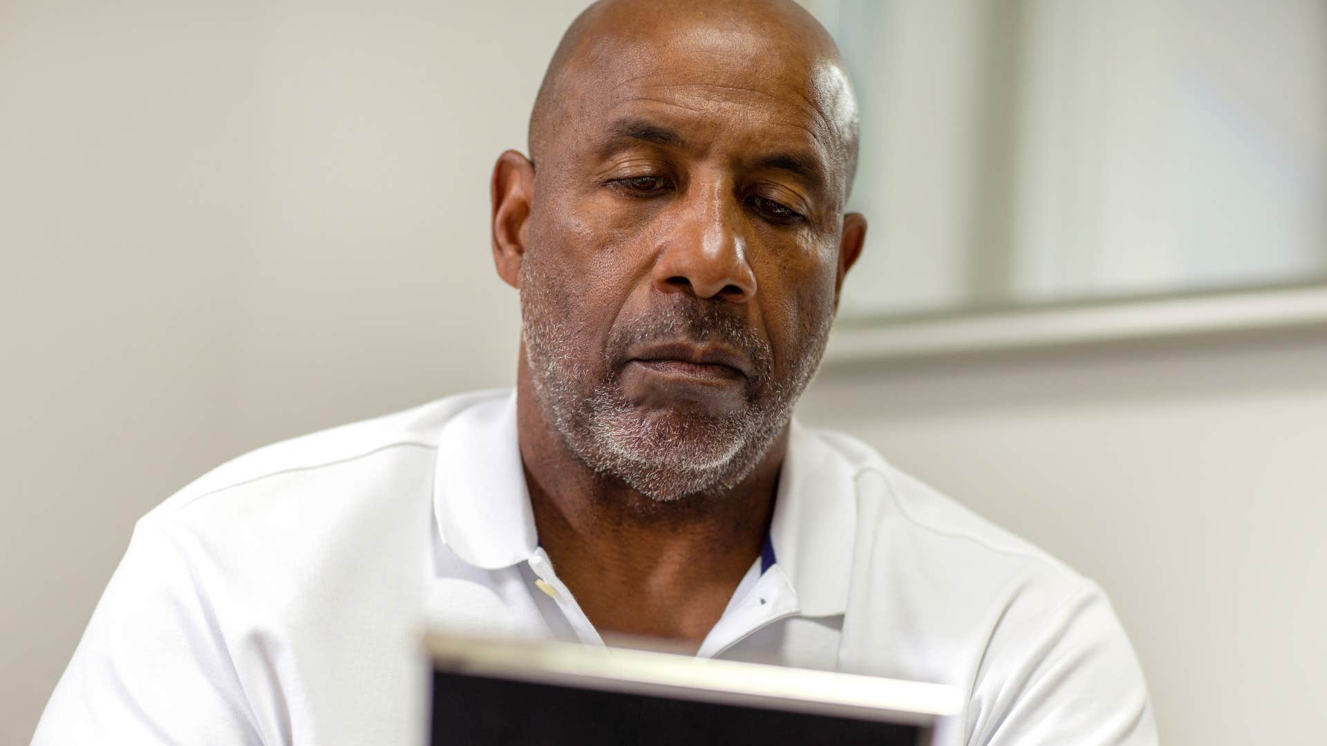 sad older man looking at photo and saying I miss the good old days