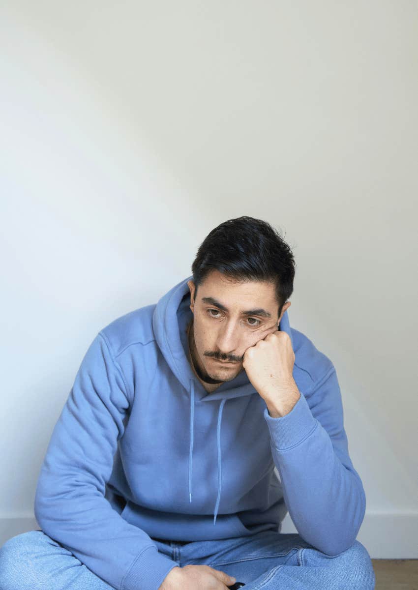 grieving man sitting alone on the floor