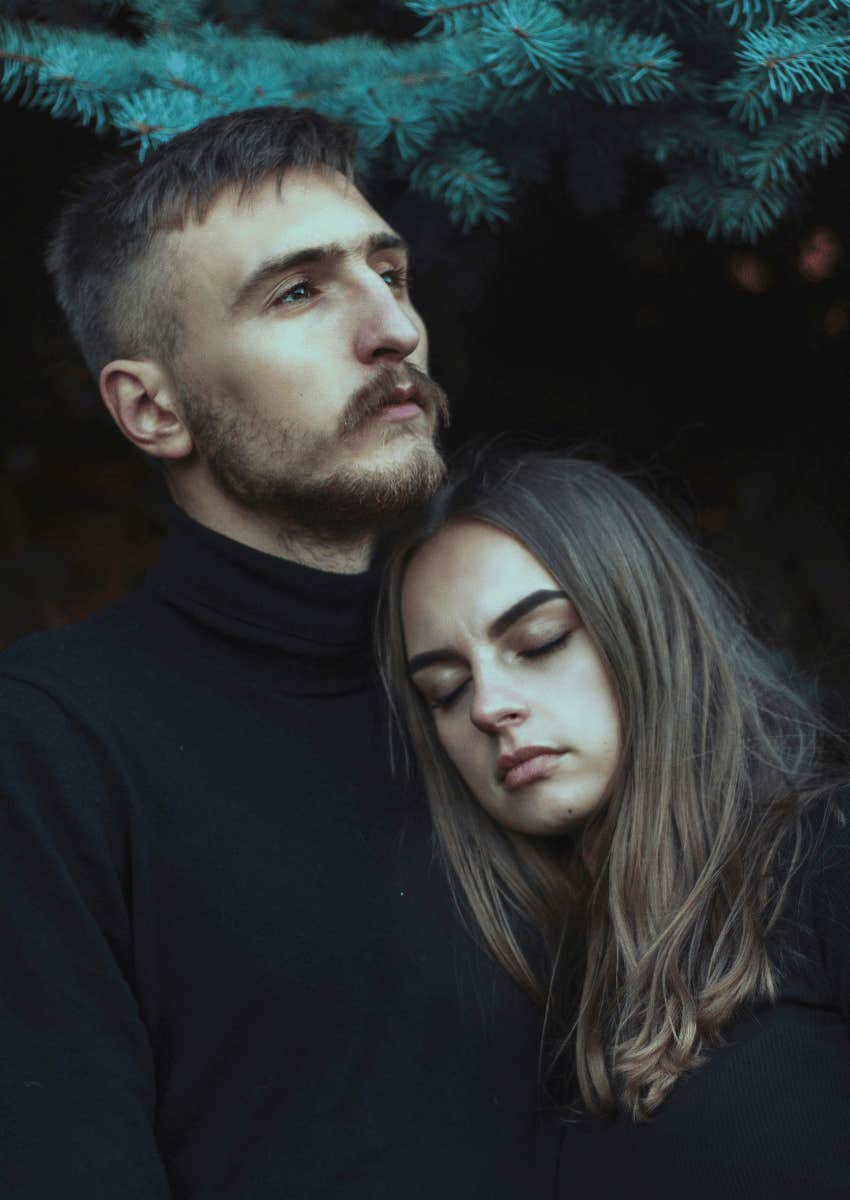 grieving parents hugging with blank expressions