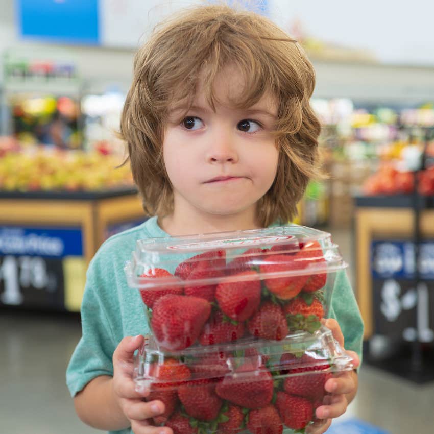 little kid holding strawberries at grocery store best to avoid eating mold caused by spoilage