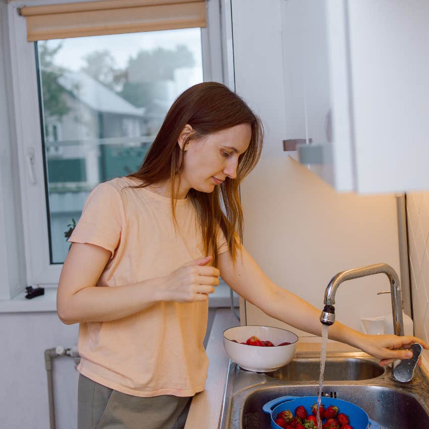 woman using a vinegar wash to clean strawberries so they don't develop mold quickly