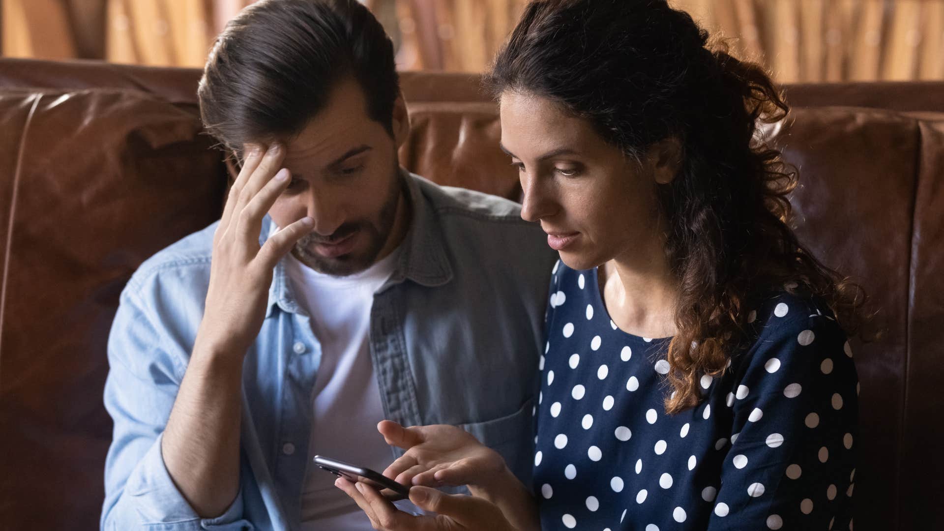 man who acts without thinking looking at his phone sitting next to his partner