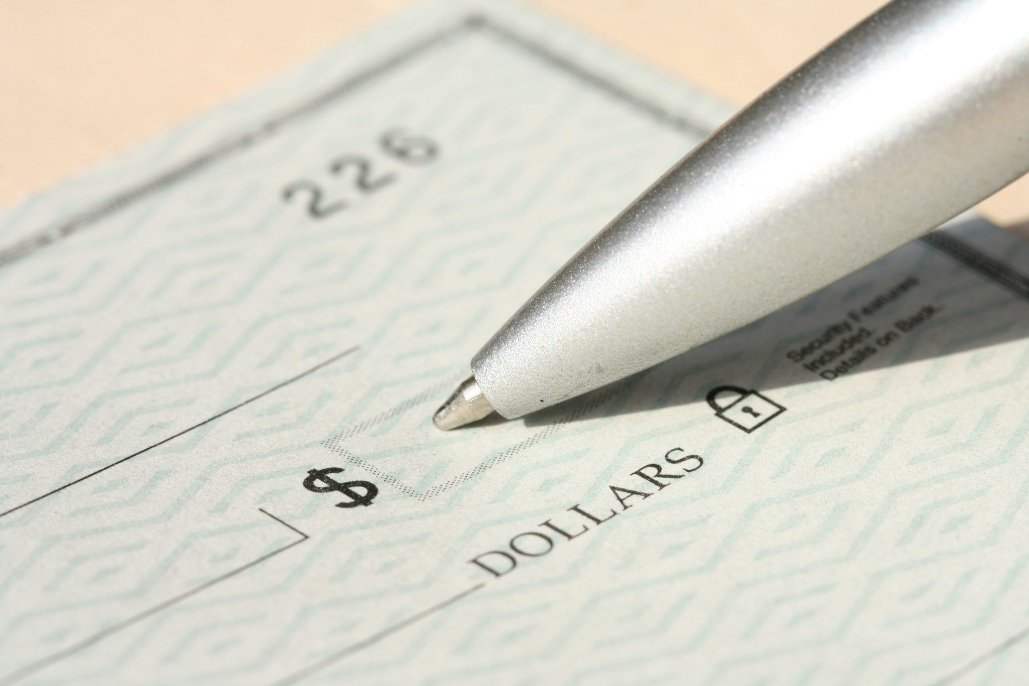 pen and blank check showing abundance habit for attracting money