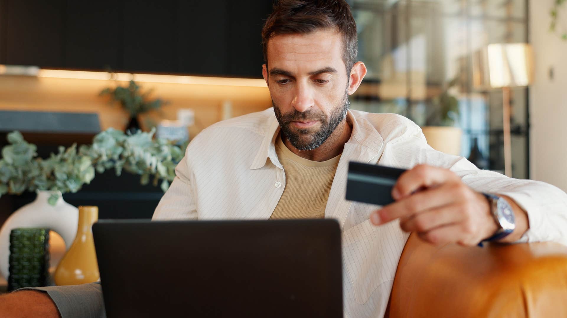 bored man making impulse purchases with his credit card