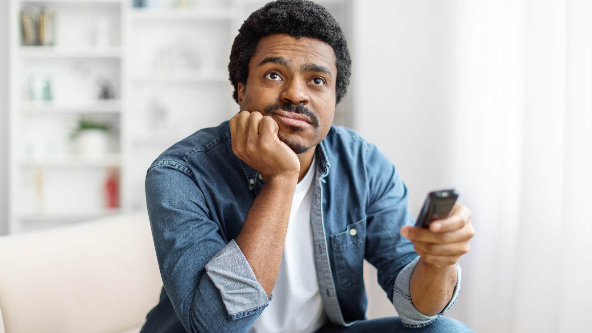 man watching mindless entertainment and TV at home