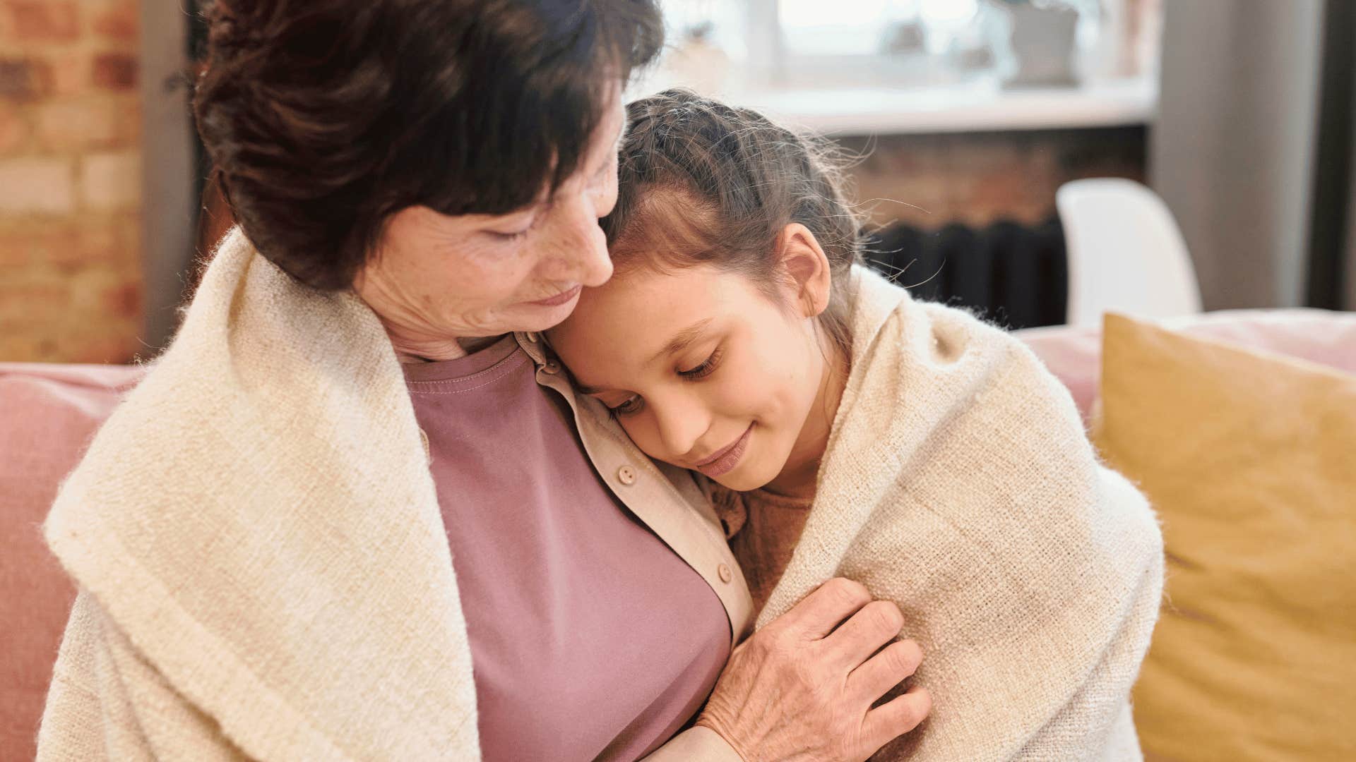 helicopter parent holding sick child in a cuddle under blanket