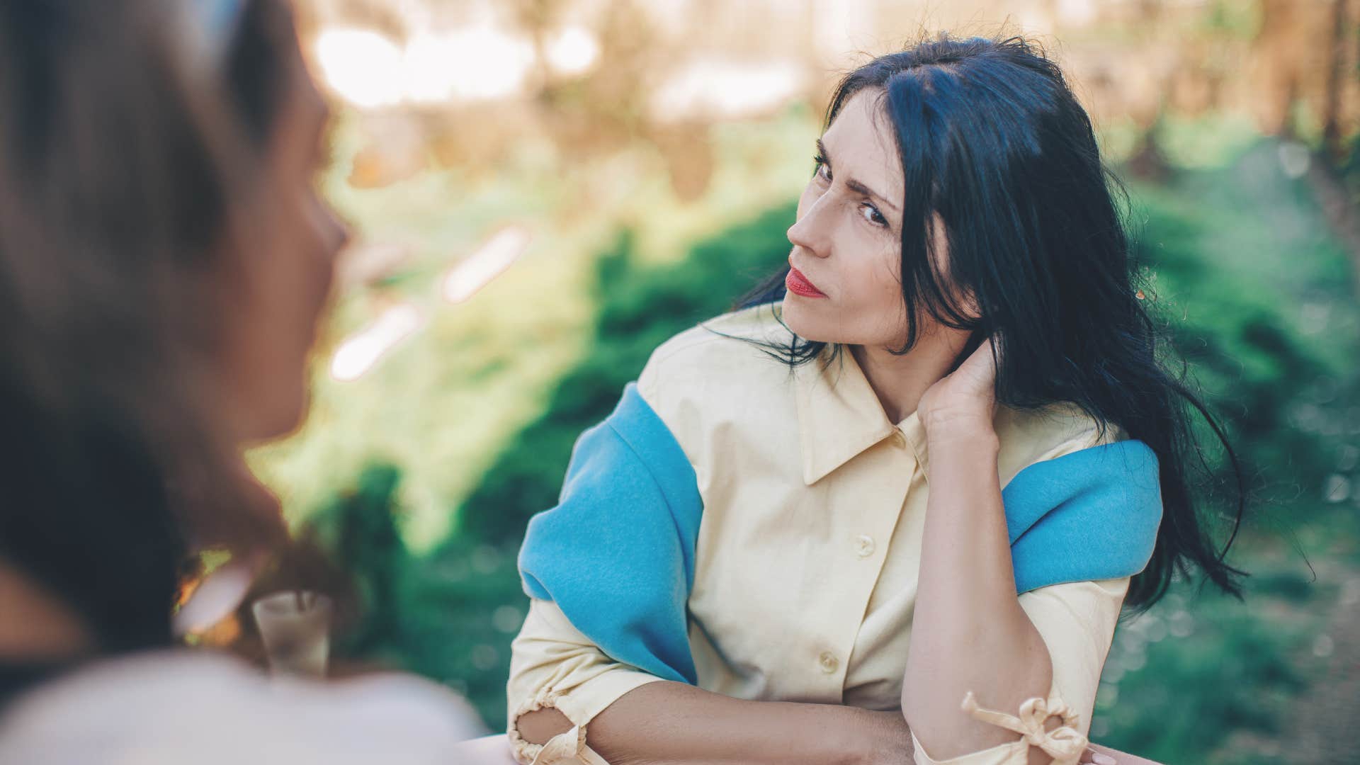 woman speaking with condescending friend asking her to rephrase what she said