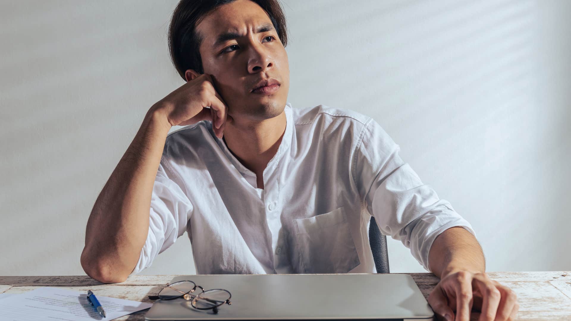 high-iq man overthinking sitting at desk