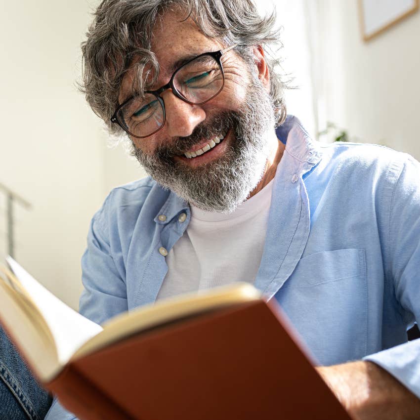 high-IQ man re-reading old book at home smiling