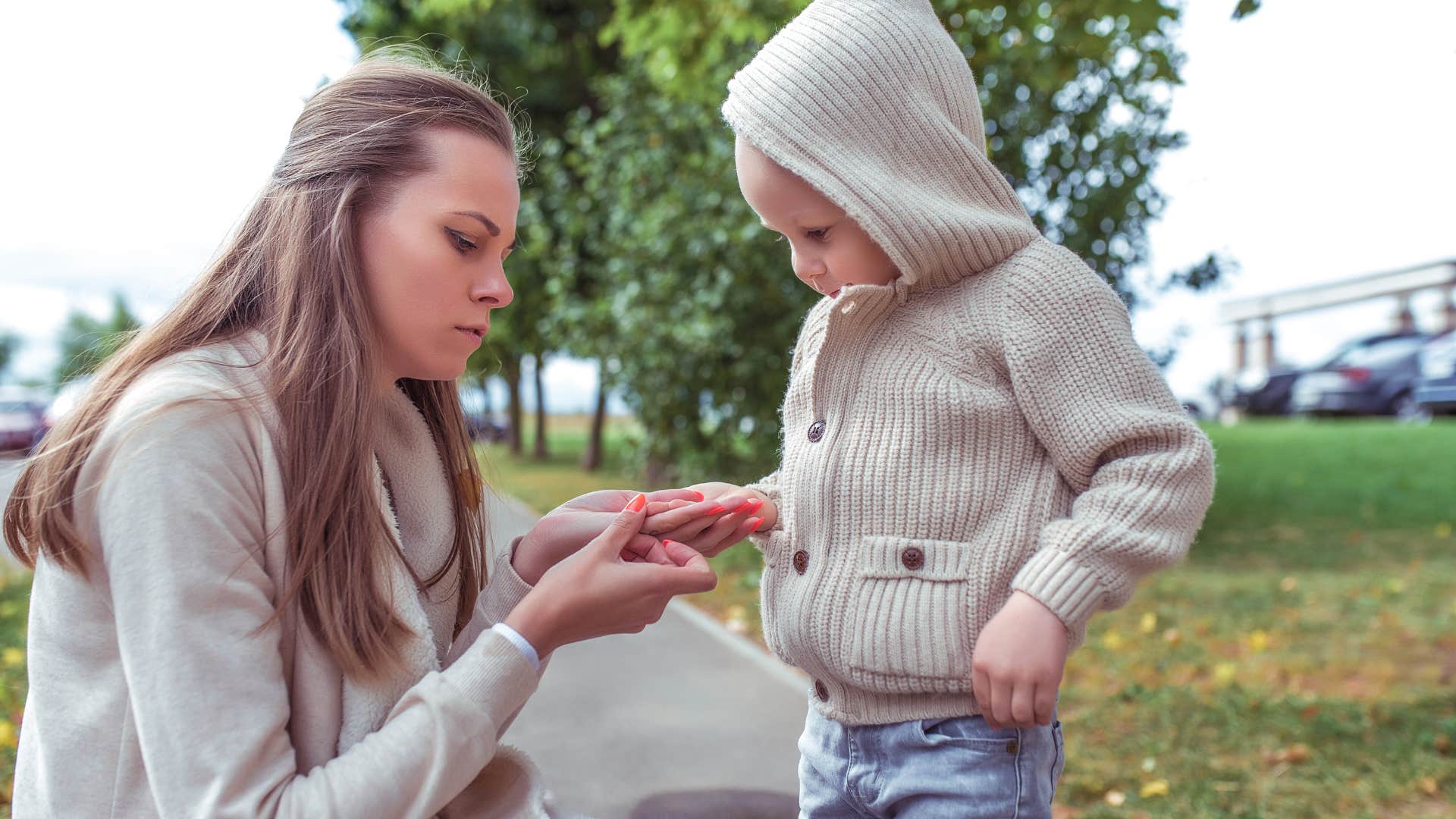 mom holding son's hand saying let me help you