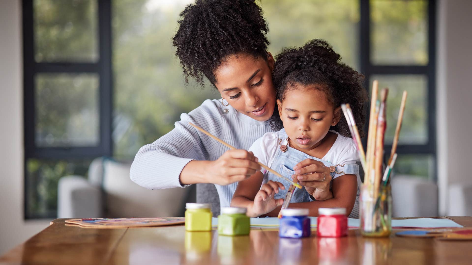 mom finger painting with daughter saying lets do it together