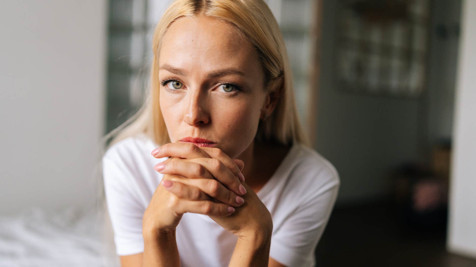 highly intelligent woman sitting in bed analyzing patterns that led up to friend cutting off contact