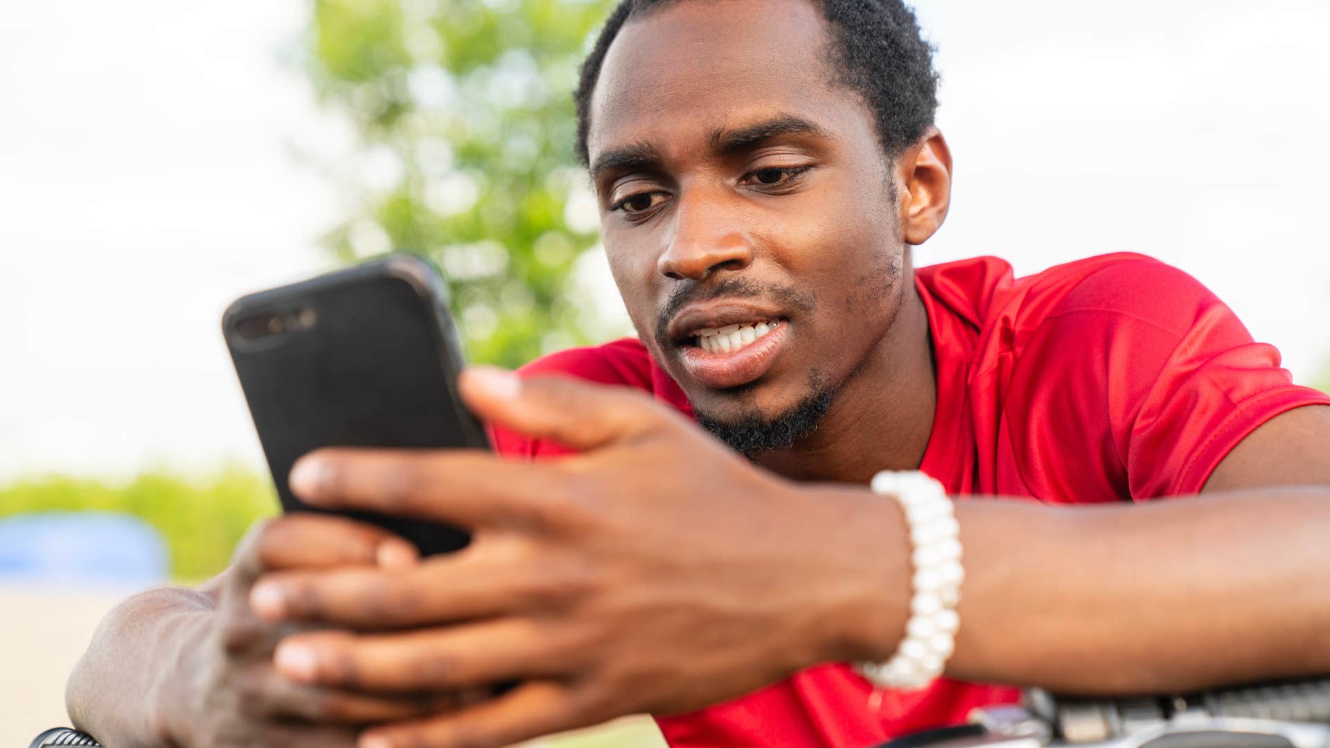intelligent focused man looking at social media on his phone