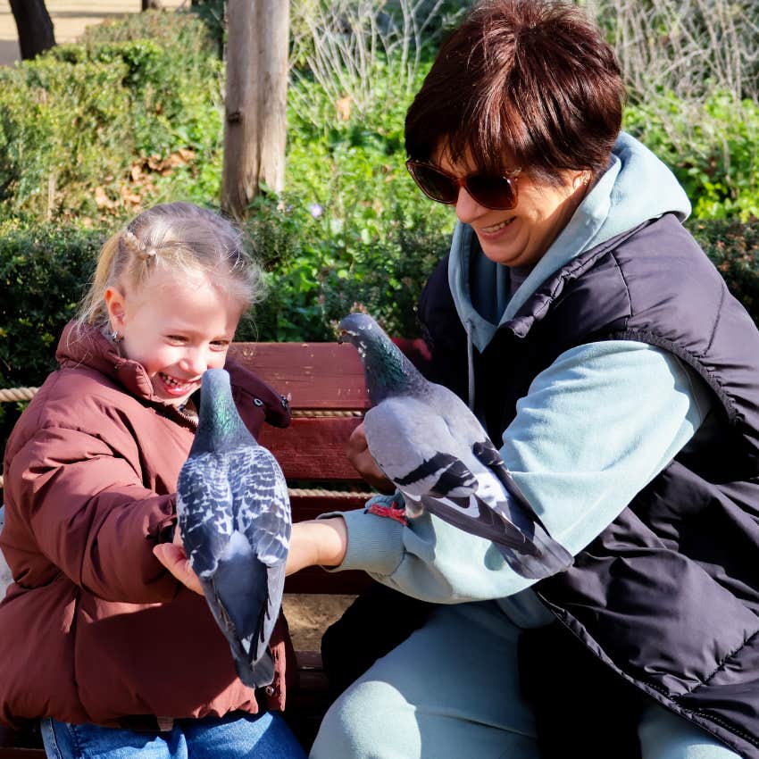 Woman who doesn't judge people based on appearance sitting with a girl and pigeons